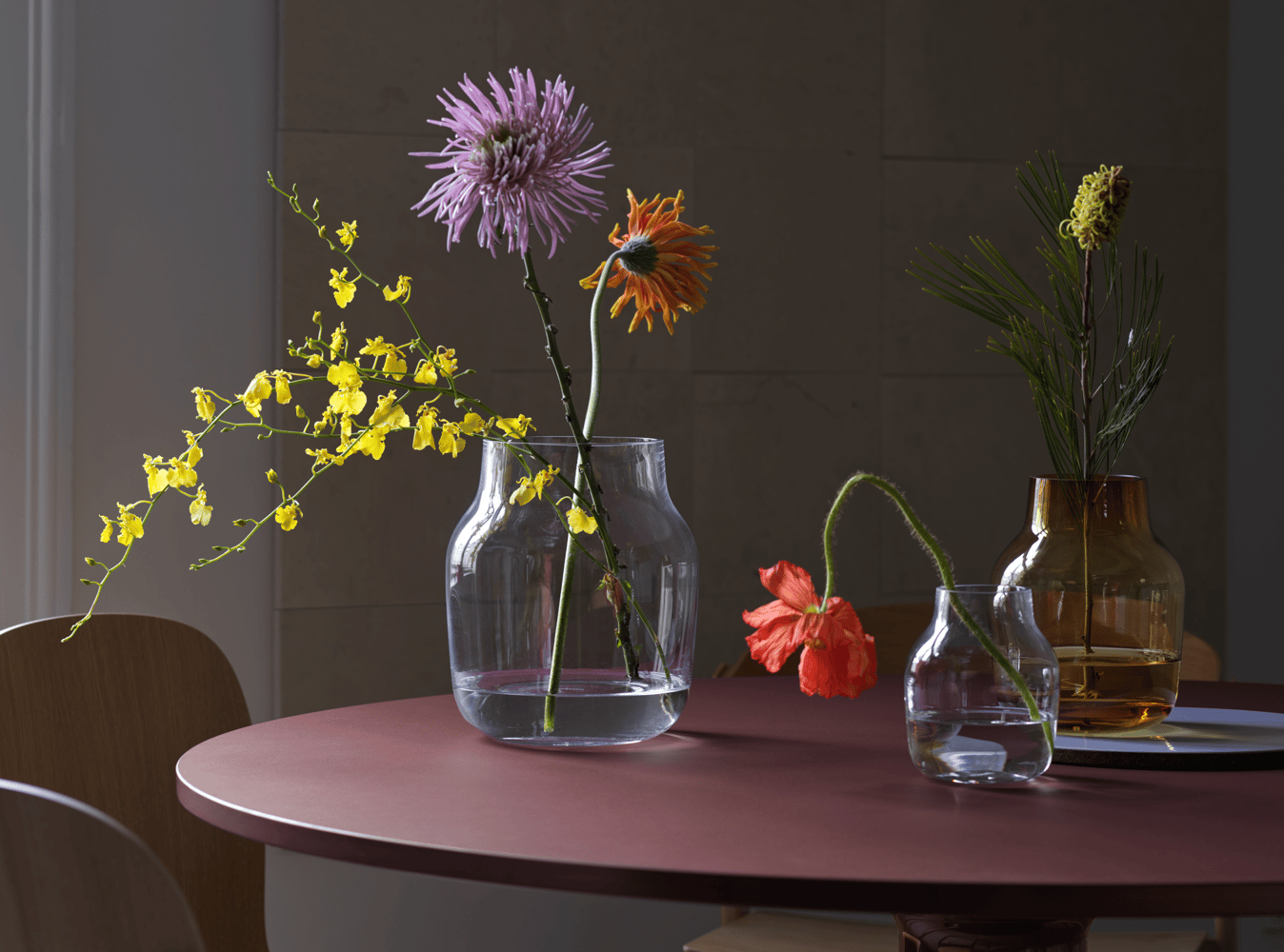 silent-vase-15-burnt-orange-20-11-clear-midst-table-120-dark-red-visu-workshop-cover-side-oak-muuto-org.png